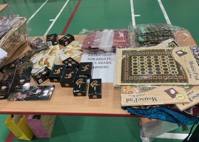 A table of Arabic quiz games and mosaic prayer mats for adult learners
