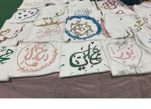 White t-shirts hand-painted with Arabic calligraphy of children's names